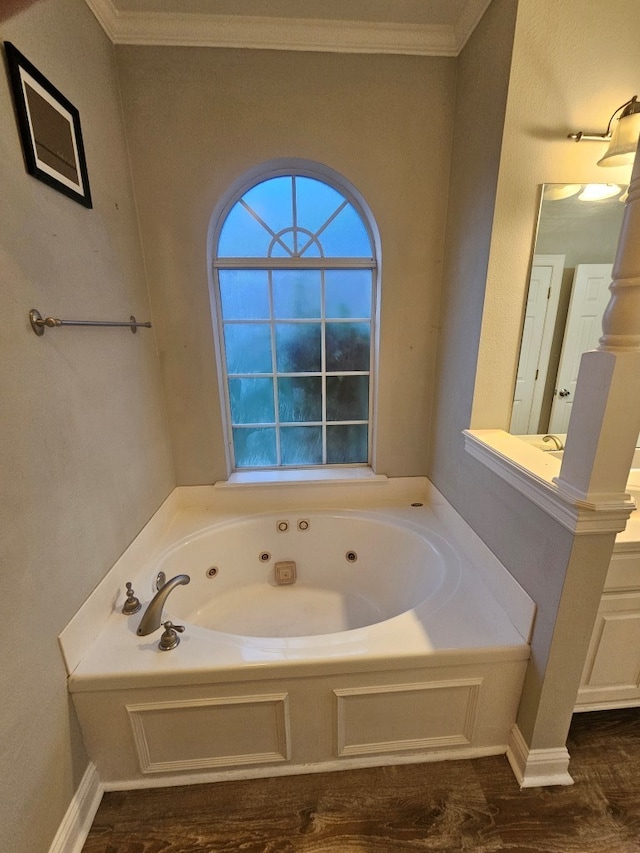 bathroom with vanity, a tub to relax in, and ornamental molding