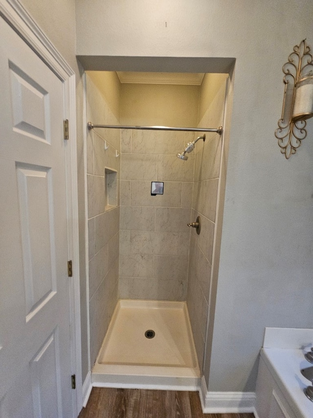 bathroom with hardwood / wood-style floors and tiled shower