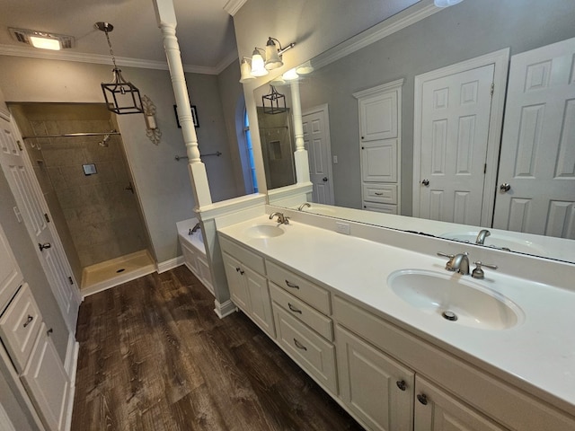 bathroom featuring hardwood / wood-style floors, vanity, a tile shower, and ornamental molding