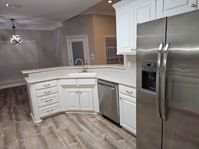 kitchen with kitchen peninsula, white cabinetry, sink, and appliances with stainless steel finishes