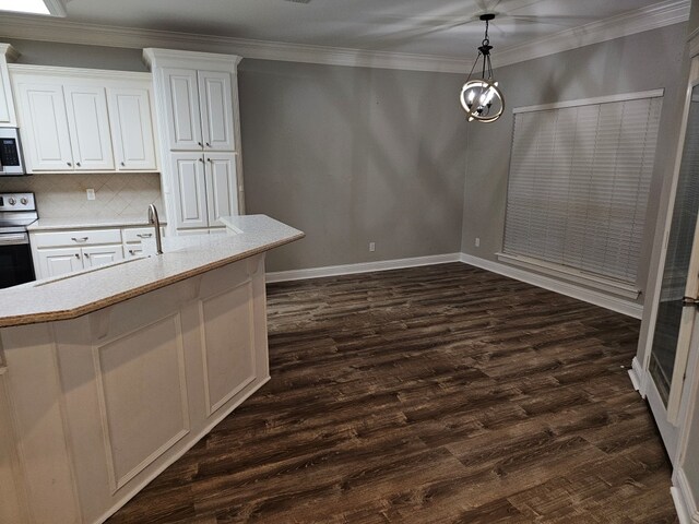 kitchen featuring white cabinets, decorative light fixtures, crown molding, and dark wood-type flooring