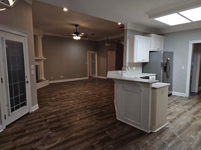 kitchen with kitchen peninsula, dark hardwood / wood-style floors, ceiling fan, ornamental molding, and white cabinetry