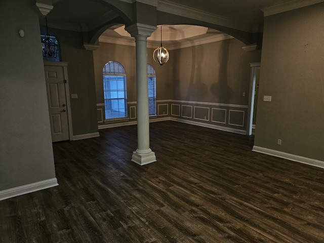 interior space featuring a chandelier, dark hardwood / wood-style flooring, decorative columns, and crown molding