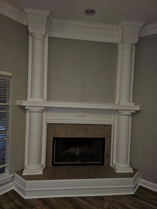 details featuring a tile fireplace, wood-type flooring, and ornamental molding