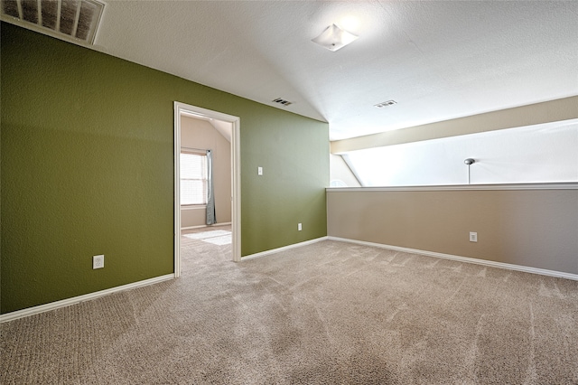 carpeted empty room featuring vaulted ceiling