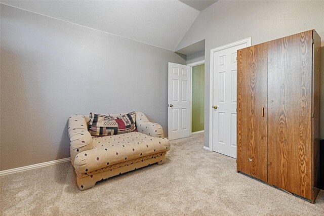 sitting room with light colored carpet and lofted ceiling