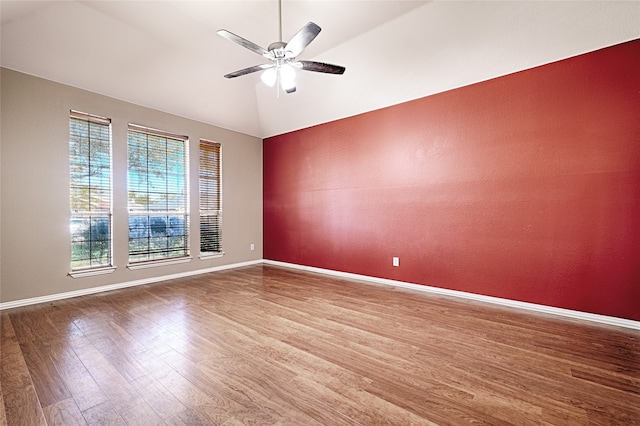 spare room featuring ceiling fan, wood-type flooring, and vaulted ceiling