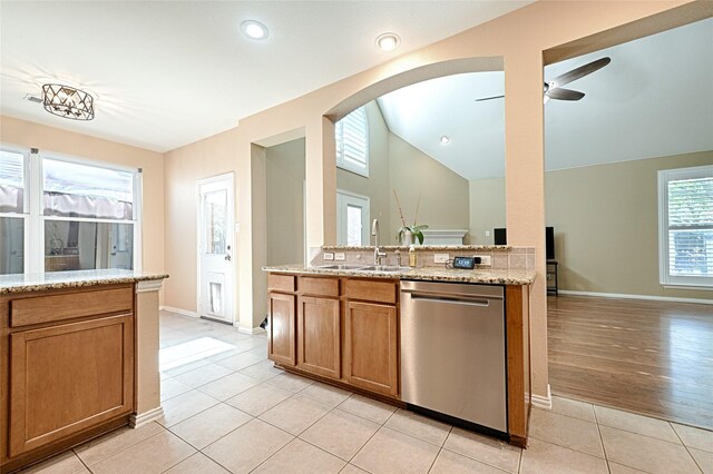 kitchen featuring sink, stainless steel dishwasher, ceiling fan, light hardwood / wood-style floors, and light stone counters