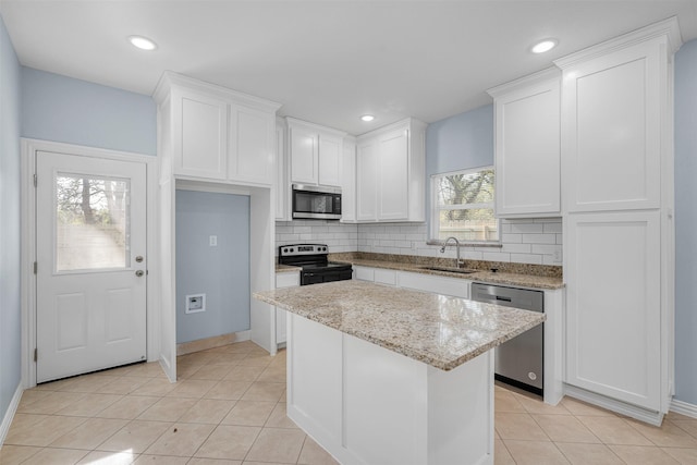 3005 Blackjack Ln, Granbury, TX 76048 - kitchen featuring stainless steel appliances, a sink, decorative backsplash, white cabinetry, and recessed lighting