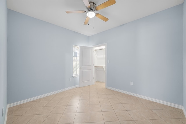 empty room with ceiling fan and light tile patterned flooring