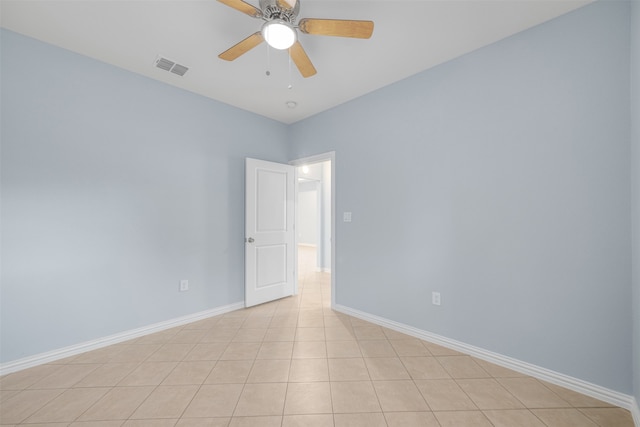 tiled spare room with ceiling fan