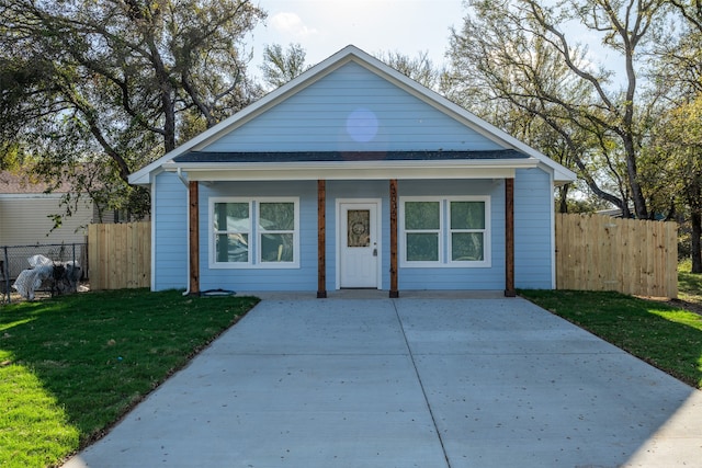 bungalow-style home with covered porch and a front yard