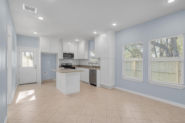 3005 Blackjack Ln, Granbury, TX 76048 - kitchen featuring stainless steel appliances, tasteful backsplash, white cabinetry, and recessed lighting
