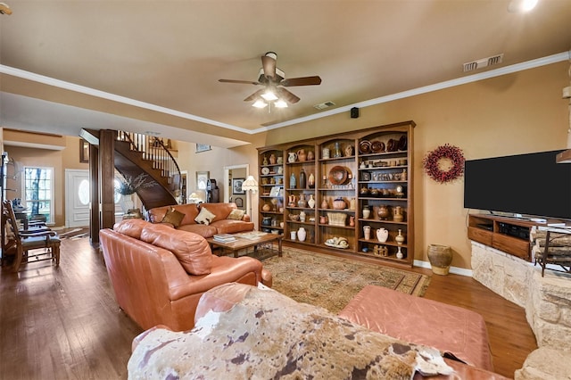 living room featuring wood finished floors, ceiling fan, visible vents, and stairs