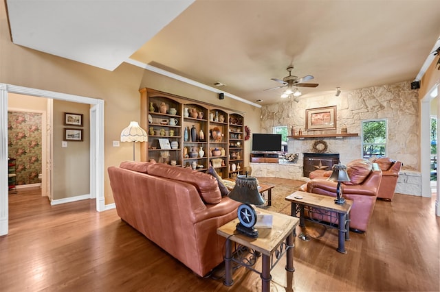 living room with a fireplace, hardwood / wood-style flooring, ceiling fan, and crown molding