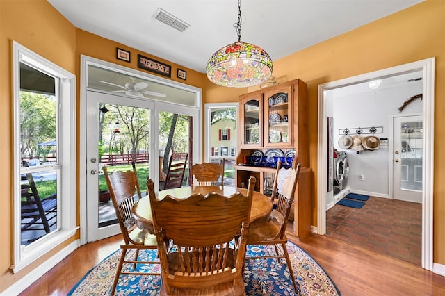 dining area featuring visible vents, baseboards, a ceiling fan, wood finished floors, and washing machine and dryer