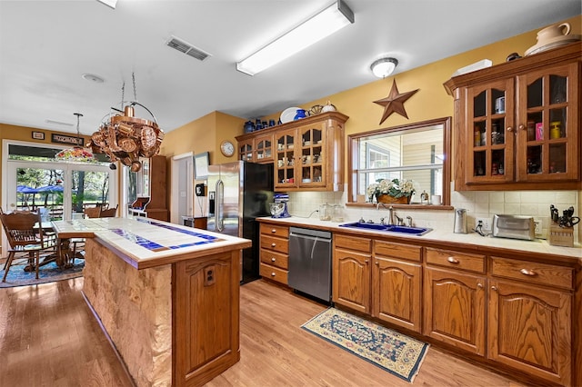 kitchen featuring appliances with stainless steel finishes, light hardwood / wood-style flooring, a wealth of natural light, and sink