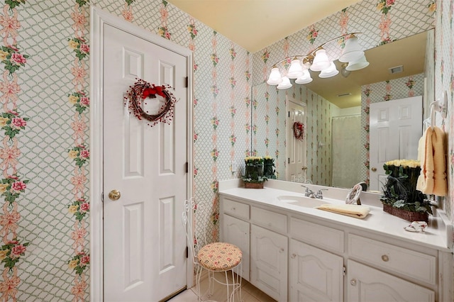 full bath featuring visible vents, vanity, and wallpapered walls