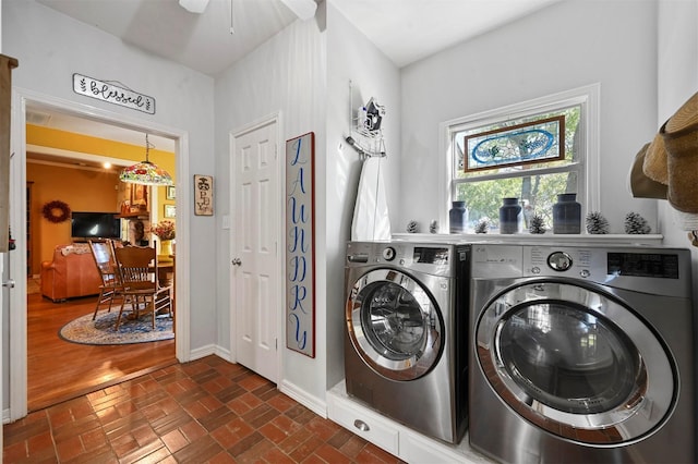 washroom with baseboards, washer and dryer, a ceiling fan, laundry area, and brick floor