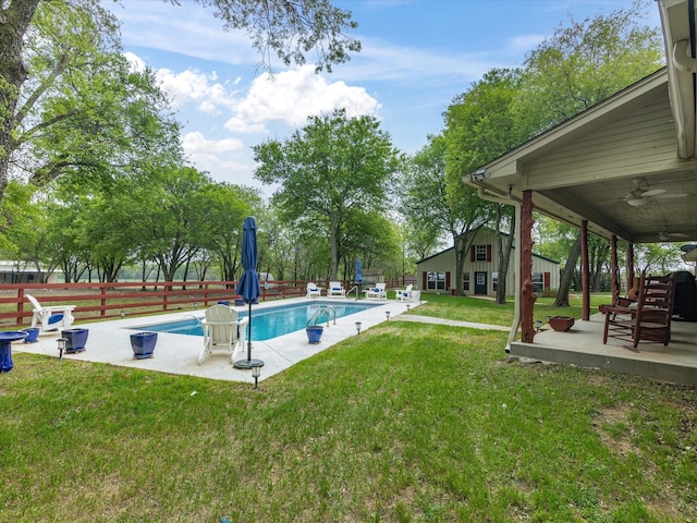 view of swimming pool with a ceiling fan, a lawn, a patio area, fence, and a fenced in pool