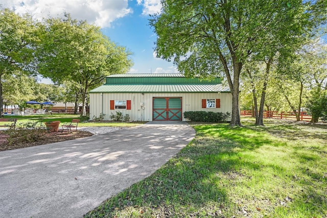 view of front of house featuring an outbuilding and a front lawn