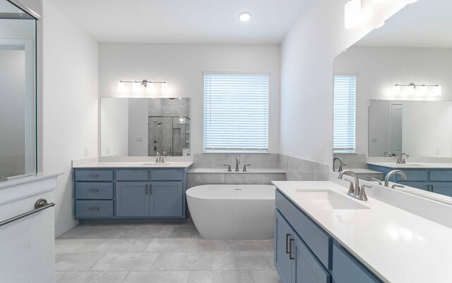 bathroom featuring vanity and independent shower and bath