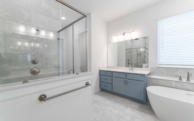 full bathroom featuring a stall shower, a freestanding tub, and vanity