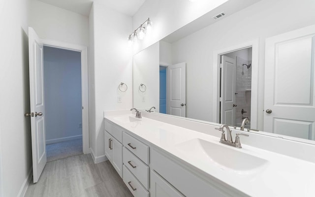 full bathroom featuring double vanity, baseboards, visible vents, and a sink