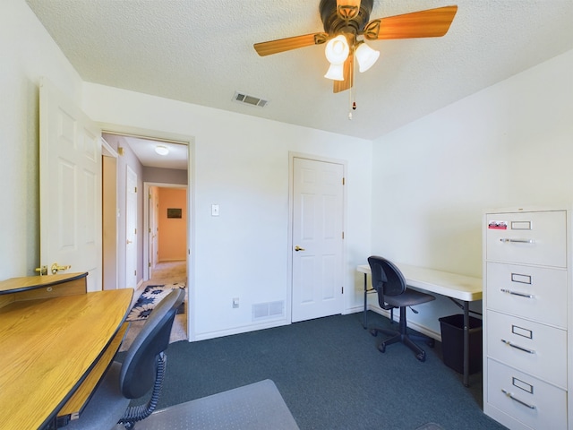 home office featuring ceiling fan, dark carpet, and a textured ceiling