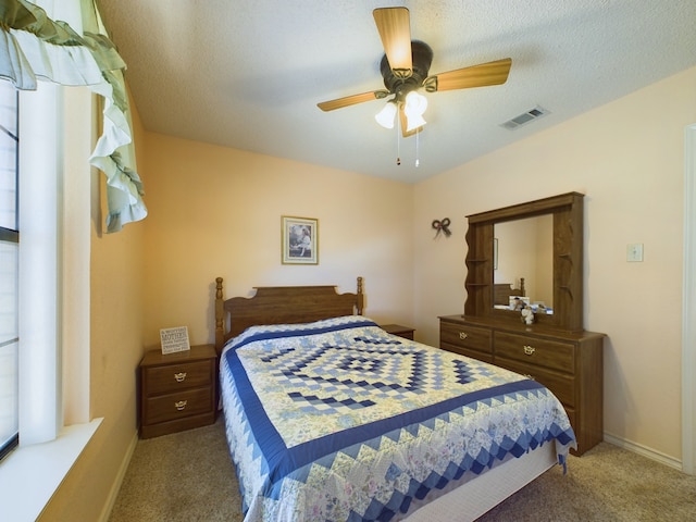 bedroom with carpet, a textured ceiling, and ceiling fan