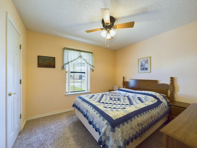 bedroom with a textured ceiling, dark carpet, and ceiling fan