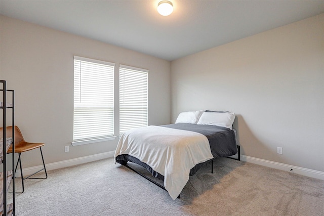 bedroom featuring light carpet and multiple windows