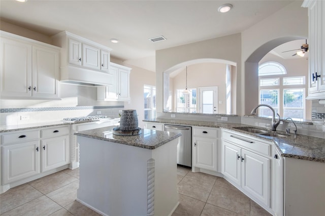 kitchen featuring a center island, white cabinets, sink, ceiling fan, and appliances with stainless steel finishes