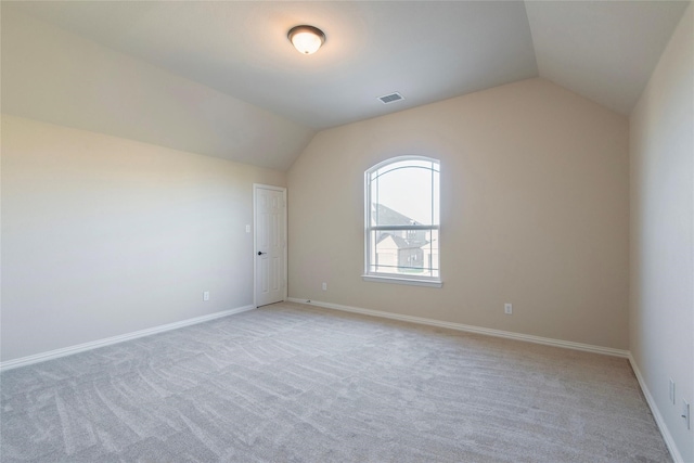 additional living space with light carpet and vaulted ceiling