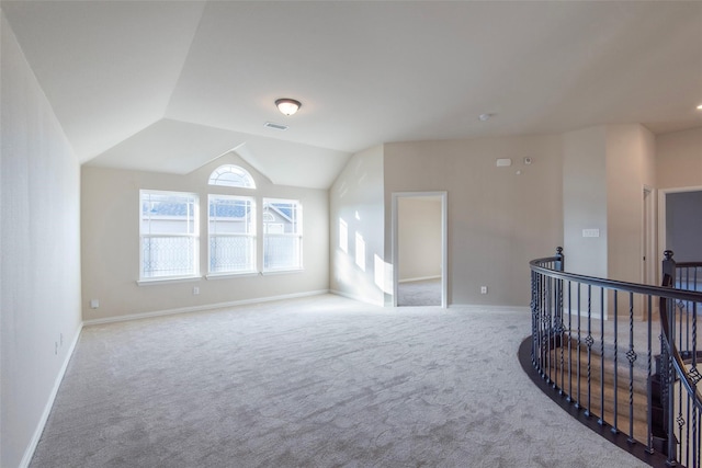 unfurnished room featuring light colored carpet and lofted ceiling