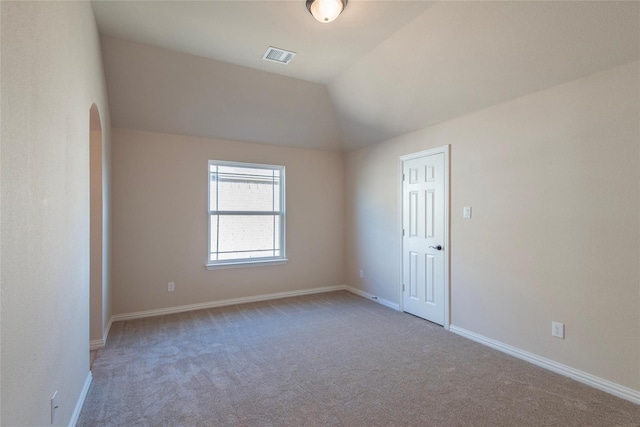 empty room with carpet flooring and lofted ceiling