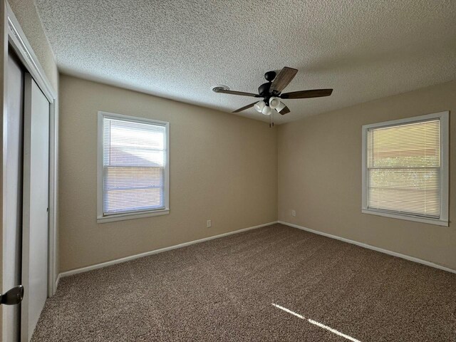 carpeted spare room with ceiling fan and a textured ceiling