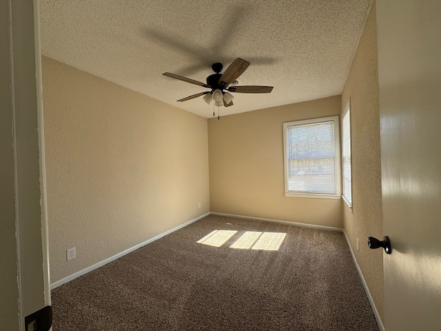 empty room with ceiling fan, carpet, and a textured ceiling