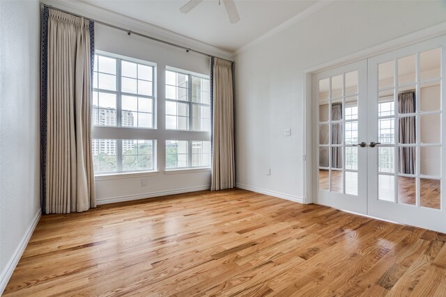 spare room featuring plenty of natural light, french doors, ornamental molding, and light hardwood / wood-style flooring