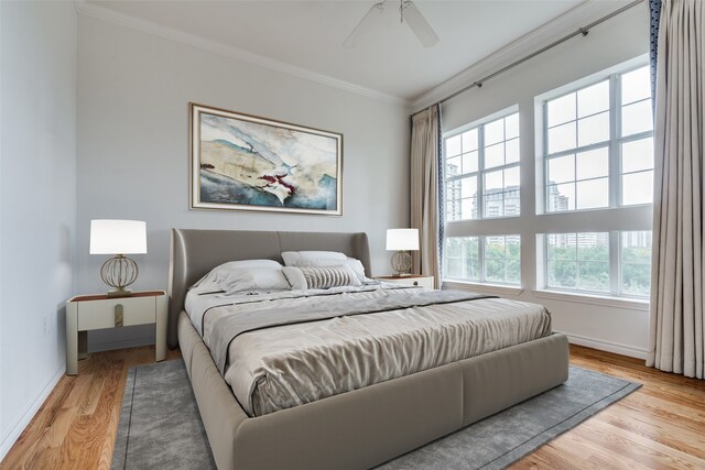 bedroom featuring light wood-type flooring, ceiling fan, and ornamental molding