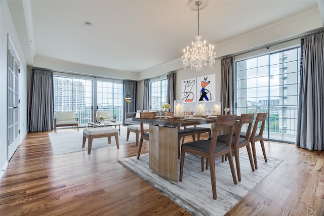 dining space with hardwood / wood-style floors, an inviting chandelier, and plenty of natural light