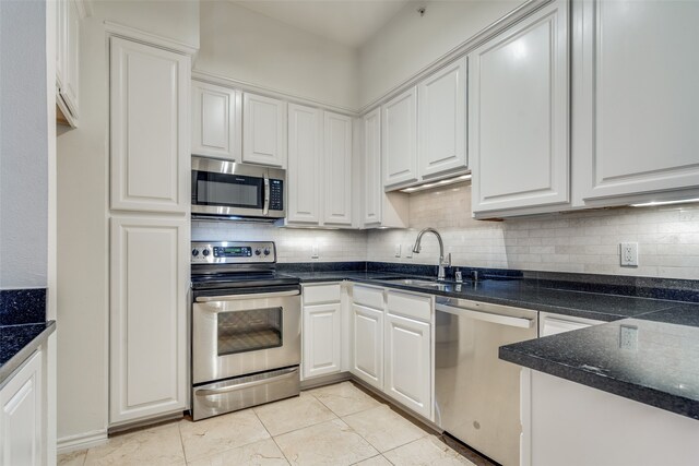 kitchen featuring backsplash, sink, white cabinets, and appliances with stainless steel finishes