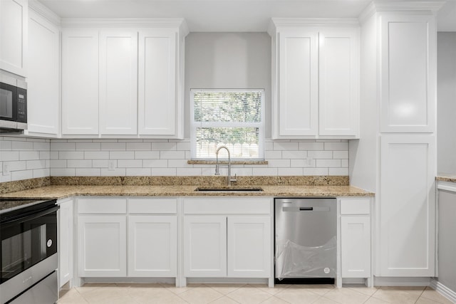 2803 Beechwood St, Granbury, TX 76048 - kitchen with appliances with stainless steel finishes, a sink, white cabinetry, and backsplash