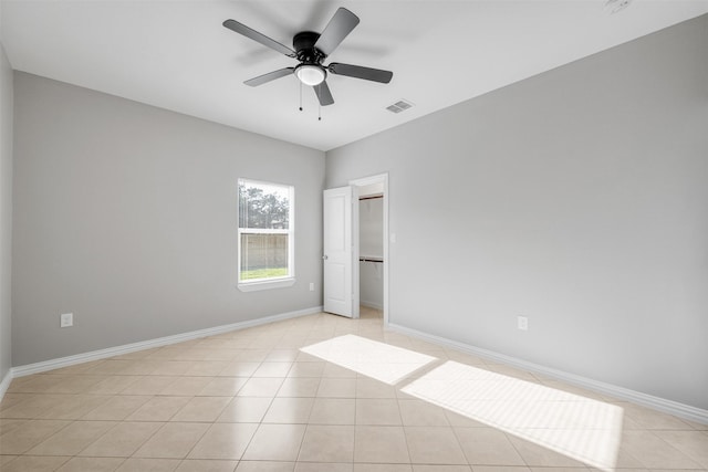 2803 Beechwood St, Granbury, TX 76048 - unfurnished bedroom featuring baseboards, a ceiling fan, light tile patterned flooring, and a walk in closet
