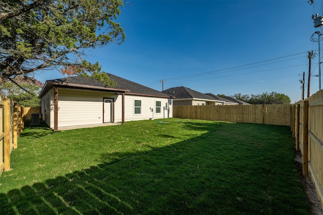 rear view of property featuring a lawn and central air condition unit