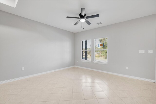 tiled spare room featuring ceiling fan