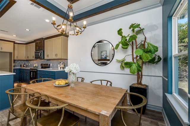 dining space featuring dark hardwood / wood-style floors, an inviting chandelier, and ornamental molding