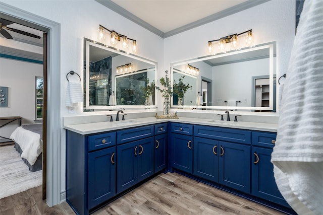 bathroom with wood-type flooring, vanity, ceiling fan, and crown molding