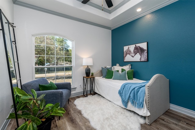 bedroom with hardwood / wood-style floors, ceiling fan, and ornamental molding