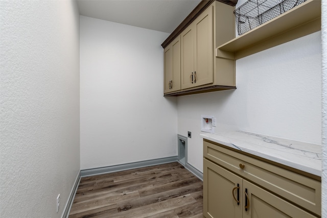 washroom with hookup for an electric dryer, washer hookup, cabinets, and dark wood-type flooring